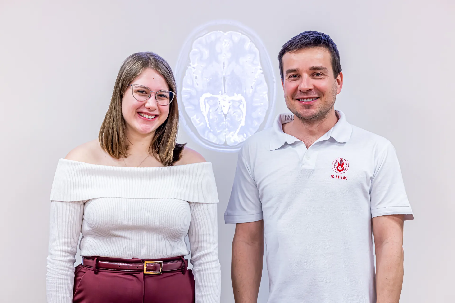 Jolana with Dr Martin Kudr from the Department of Paediatric Neurology, Second Faculty of Medicine, Charles University in Prague and Motol University Hospital. In the background a picture of Jolana's brain.